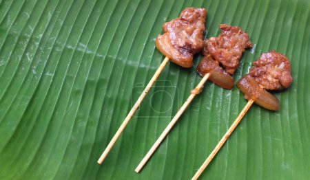 Téléchargez les photos : Porc grillé Mettez sur une toile de fond de feuille de banane verte est un aliment facile à manger pour les Thaïlandais, populaire pour le petit déjeuner. - en image libre de droit