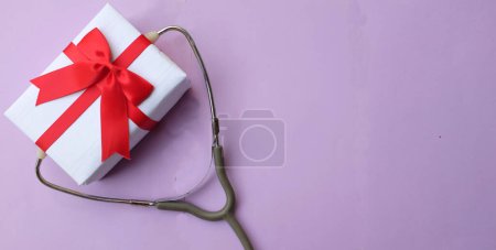 Photo for Medical stethoscope with gift box isolated on a purple pastel background. concept christmas and new year.horizontal photo - Royalty Free Image