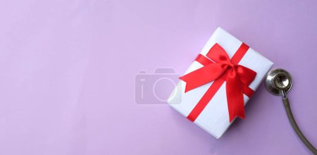 Photo for Medical stethoscope with gift box isolated on a purple pastel background. concept christmas and new year.horizontal photo - Royalty Free Image