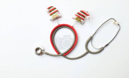 Photo for Medical stethoscope with  decorated Beautiful headband  Decorative red Santa Hat. Background for congratulations to doctors.  life christmas and new year holidays. - Royalty Free Image