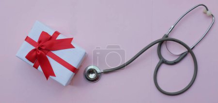 Photo for Medical stethoscope with gift box isolated on a pink pastel background. concept christmas and new year.horizontal photo - Royalty Free Image
