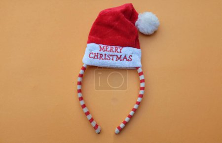 Foto de Hermosa diadema decorativa de Santa Sombrero rojo aislado en un fondo anaranjado.concepto de alegre fiesta de Navidad, Año Nuevo viene pronto, decoración de temporada festiva con elementos de Navidad - Imagen libre de derechos