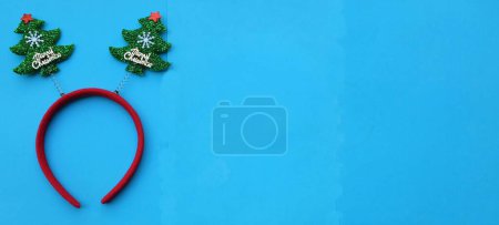 Foto de Decorado Hermosa diadema árboles de Navidad divertidos aíslan en un fondo azul. Concepto de fiesta de Navidad alegre, Año Nuevo viene pronto, decoración de temporada festiva con elementos de Navidad - Imagen libre de derechos