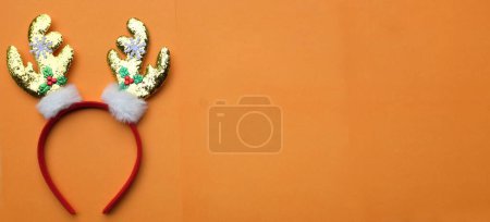 Foto de Linda diadema de Navidad, cuernos de ciervo de Navidad aislar en un fondo naranja. concepto de fiesta de Navidad alegre, Año Nuevo viene pronto, decoración de temporada festiva con elementos de Navidad - Imagen libre de derechos