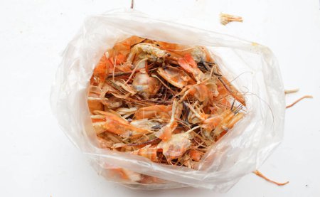 Téléchargez les photos : Un tas d'os de crevettes, d'os, de coquille de crevettes ou de restes de nourriture après avoir mangé. Des restes de crevettes frites. déchets alimentaires. - en image libre de droit