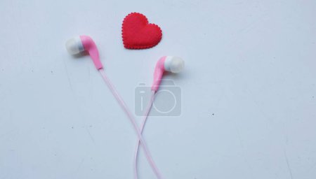 Light pink headphone,earphones,wireless headphonesbluetooth headphones, withbluetooth headphones isolated on white background. Love music, valentines day,romantic,Love listening to music concept.