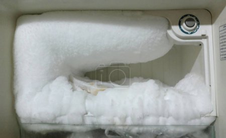 white freezer refrigerator is opened.large amount of ice in freezer, ice build up in an empty refrigeratorEmpty fridge with ice. ice in freezer in the refrigerator