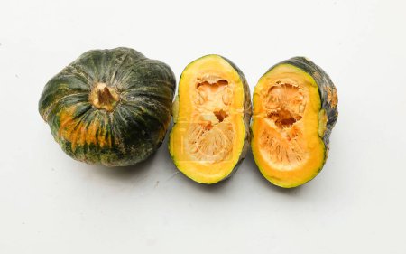 Photo for A pile of fresh raw green Japanese pumpkin (Cucurbita moschata) ,Kabocha squash,both in ball and cut, showing yellow flesh isolated on a white backdrop.Healthy food vegetable, fruit, and food business - Royalty Free Image