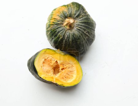 Photo for A pile of fresh raw green Japanese pumpkin (Cucurbita moschata) ,Kabocha squash,both in ball and cut, showing yellow flesh isolated on a white backdrop.Healthy food vegetable, fruit, and food business - Royalty Free Image