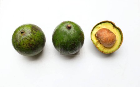 fresh green ripe avocado Alpukat or Avocado (Persea americana) fruit cut in half sliced with leaves isolated on white backdrop. tropical exotic fruit and healthy fruits