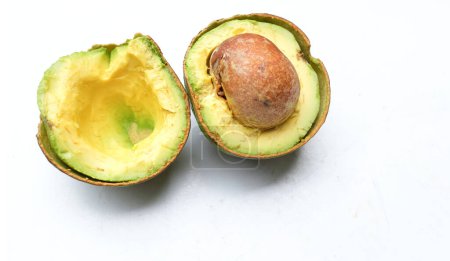 fresh green ripe avocado Alpukat or Avocado (Persea americana) fruit cut in half sliced with leaves isolated on white backdrop. tropical exotic fruit and healthy fruits