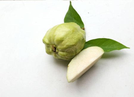 goyave verte crue (Psidium guajava L) fraîche coupée en deux tranches avec des feuilles isolées sur fond blanc. fruits exotiques tropicaux et fruits sains