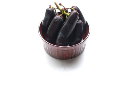 Bunch of fresh Sweet black seedless Moon Drops grape,Purple Witch Finger grapes,Sapphire Grapes or Witch Fingers grape in a bowl isolated on white backdrop.black grapes. 