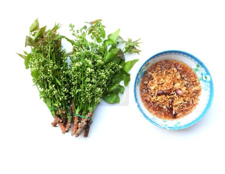 Blick von oben auf einen Neem, siamesischen Neem-Baum, (Azadirachta indica) Gemüse mit süßer Sauce (thailändischer Name ist Sadao nam pla wan) und gegrilltem Wels in der Küche zum Servieren, traditionelle thailändische Küche 