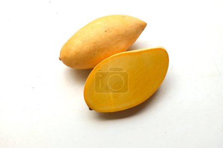 Foto de Mango amarillo maduro dorado, mango nam dok mai mango, barracuda mango (mangifera indica) rey de fruta cortada por la mitad en rodajas con hojas aisladas sobre un fondo blanco.frutas exóticas tropicales y frutos saludables - Imagen libre de derechos