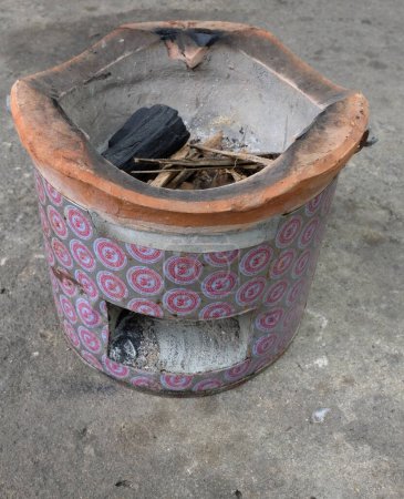 Image of a charcoal turtle,brazier stove  on a cement floor.rural outdoor cooking thai style.pottery stove ashes rural Thailand, which has been used for a long time