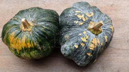 A pile of fresh raw green Japanese pumpkin (Cucurbita moschata) ,Kabocha squash,isolated on a wooden table old backdrop.Healthy food vegetable, fruit, and food business idea
