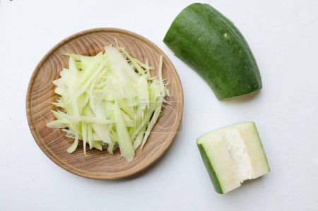 Chopped papaya noodles or Chopped raw papayas along  in a wooden plate isolate on a white background, for prepare made a menu of papaya salad or Som Tam in Thai call. papaya salad Spicy flavor,thai food,Traditional thai 