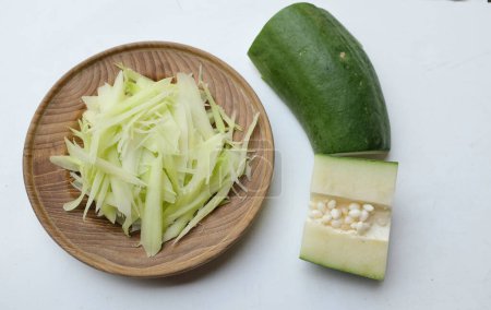 Chopped papaya noodles or Chopped raw papayas along  in a wooden plate isolate on a white background, for prepare made a menu of papaya salad or Som Tam in Thai call. papaya salad Spicy flavor,thai food,Traditional thai 
