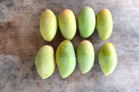 ripe yellow mango golden mango,yellow mango ,golden nam dok mai mango ,barracuda mango ( mangifera indica) king of fruits isolated on a wooden table background.tropical fruit in thailand
