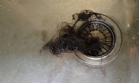 cerrar un desperdicio de fragmentos de cabello causa tubería obstruida en el fregadero en el concepto drenaje de la cocina.