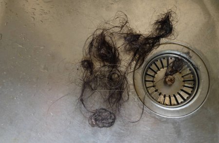 cerrar un desperdicio de fragmentos de cabello causa tubería obstruida en el fregadero en el concepto drenaje de la cocina.