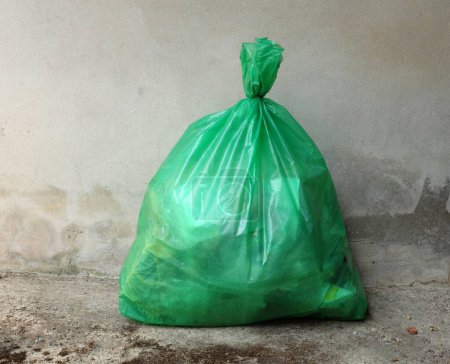 Photo for One green trash bags lay on the ground.  pile of large plastic bag waste. smelly trash pile green bag. dirty disposal dump smelly trash.concept environmental protection,waste management andenvironment - Royalty Free Image