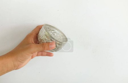 Asian woman's hand holding silver water bowl doing bathing or watering isolate on white background.