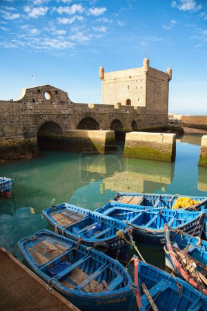Téléchargez les photos : Les bateaux de pêche bleus, filets de pêche et en arrière-plan la tour de la Sqala - en image libre de droit