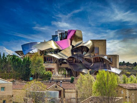 Foto de Elciego, Álava, España; 28 de marzo de 2024: Vista frontal de un edificio moderno con estructuras onduladas de aluminio diseñado por el arquitecto Frank O. Gehry, para las bodegas de Rioja llamadas Marques de Riscal - Imagen libre de derechos