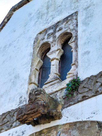 Window of pre-Romanesque origin in the chapel of San Bartolome de Nava cemetery and and the figure of a bear with a wild boar in its mouth, Nava, Asturias, Spain