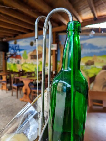 Une bouteille de Sidra de Asturias sur un dispositif pour verser l'iside d'un verre, appelé escanciar, Ceceda, Asturies, Espagne