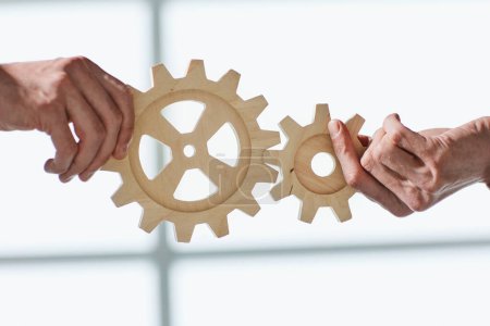 Photo for Two business people united wooden cogs gears - Royalty Free Image