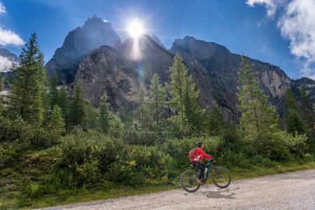Téléchargez les photos : Jolie femme âgée chevauchant son vélo de montagne électrique dans la vallée d'Innerfeld dans les Dolomites Sexten près du village d'Innichen, parc national de Tre cime, Tyrol du Sud, Italie - en image libre de droit
