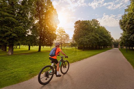 Foto de Agradable mujer con bicicleta de montaña eléctrica, ciclismo en la luz de la mañana en el valle del Neckar carril bici cerca de Ludwigsburg, Baden Wrttemberg, Alemania - Imagen libre de derechos