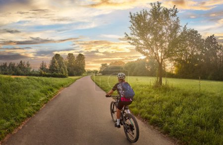 Téléchargez les photos : Belle femme avec VTT électrique, vélo dans la lumière du matin lunatique dans la vallée du Neckar piste cyclable près de Ludwigsburg, Baden Wrttemberg, Allemagne - en image libre de droit