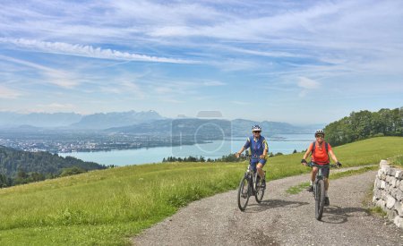 Foto de Dos amigas mayores divirtiéndose durante un recorrido en bicicleta por encima del lago Constanza, Bregenz, Vorarlberg, Austria - Imagen libre de derechos