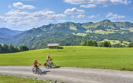 Foto de Dos amigas mayores divirtiéndose durante un recorrido en bicicleta por el bosque de Bregenz cerca de Sibratsgfll, Vorarlberg, Austria - Imagen libre de derechos