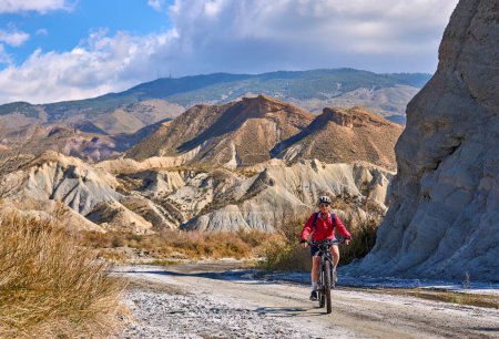 Foto de Mujer mayor agradable y activa con su bicicleta de montaña eléctrica en un recorrido por el desierto de Tabernas cerca de Almería, Andlusia, España - Imagen libre de derechos