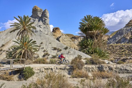 Photo for Nice, active senior woman with her electric mountain bike on a trail tour in the desert of Tabernas near Almeria, Andlusia, Spain - Royalty Free Image