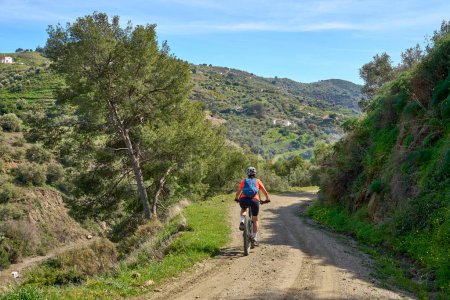 Photo for Nice  woman cycling with her electric mountain bike in the Sierra de Tejada near Nerja, Andalusia, Spain - Royalty Free Image