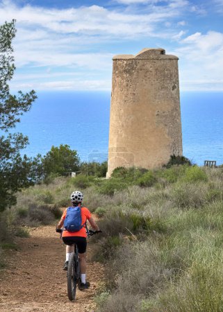 Téléchargez les photos : Belle femme âgée vélo avec son vélo de montagne électrique sur la côte de la Costa Blanca près de Nerja, Andalousie, Espagne - en image libre de droit