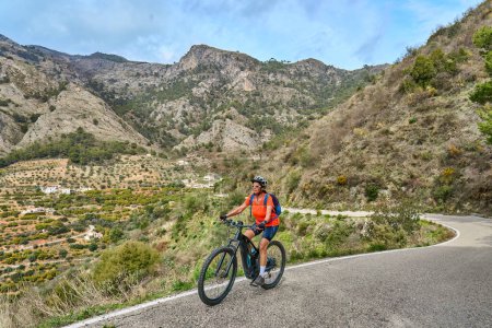 Photo for Nice  woman cycling with her electric mountain bike in the Sierra de Tejada near Nerja, Andalusia, Spain - Royalty Free Image