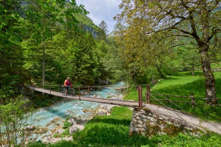 nice senior woman on a bike tour along  River Soca with her electric mountain bike  in the Triglav National Park in Slovenia 