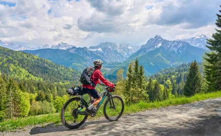 Photo for Nice woman on a bike tour along  River Soca with her electric mountain bike  in the Triglav National Park in Slovenia - Royalty Free Image