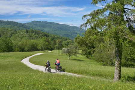Photo for Active senior couple on a mountain bike tour at Vri Pass in the Triglav National Park, Julian Alps above Kranska Gora in Slovenia - Royalty Free Image