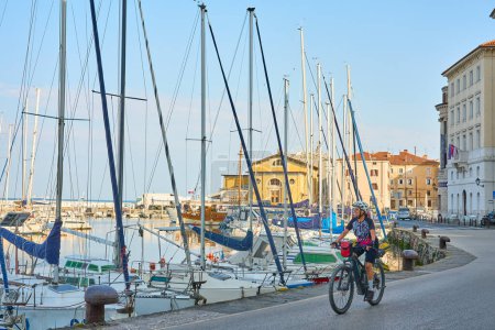 Photo for Beautiful senior woman cycling in downtown Piran in Slovenia, Europe - Royalty Free Image