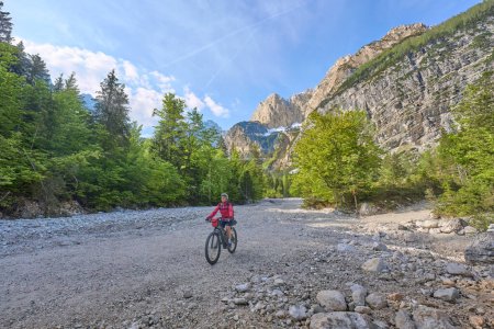 Téléchargez les photos : Belle femme en balade à vélo le long de la rivière Soca avec son vélo de montagne électrique dans le parc national du Triglav en Slovénie - en image libre de droit
