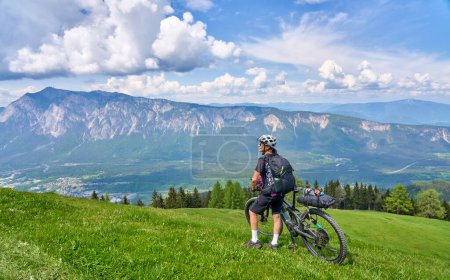 Photo for Active woman on a mountain bike tour in the carinthian alps above Villach in Austria - Royalty Free Image
