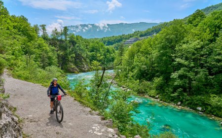 Foto de Agradable mujer en un recorrido en bicicleta a lo largo del río Soca con su bicicleta de montaña eléctrica en el Parque Nacional Triglav en Eslovenia - Imagen libre de derechos